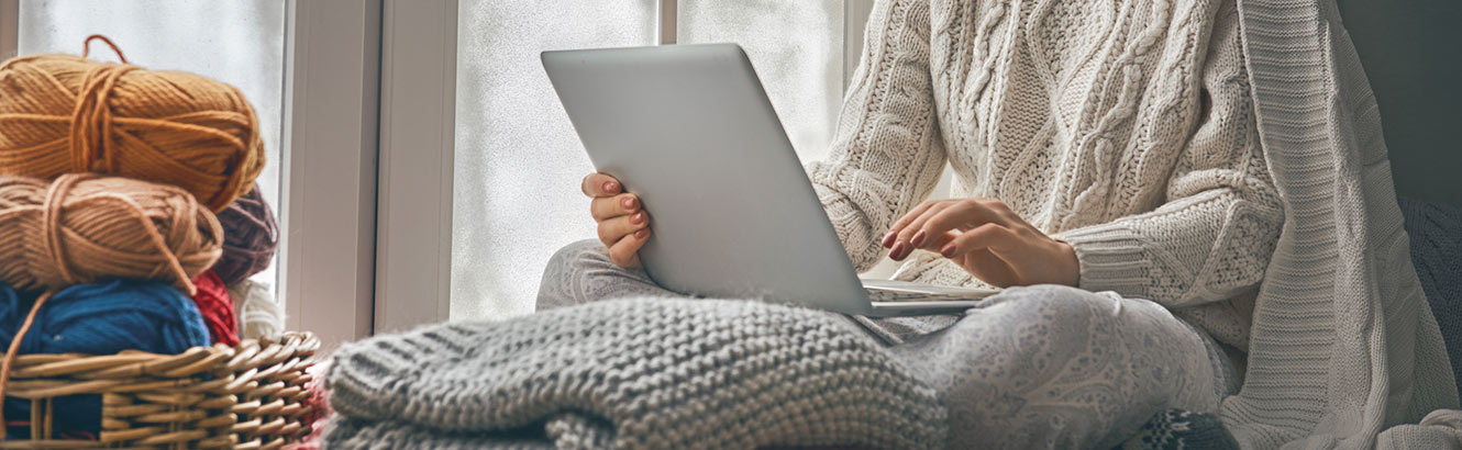 woman surfing her computer by the window